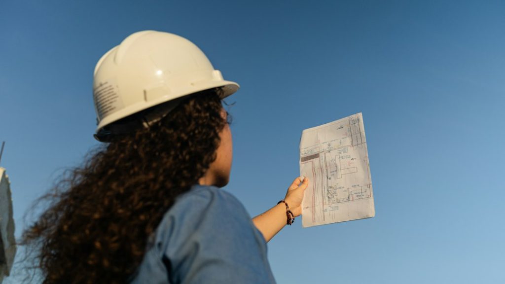 Profesional de obra civil revisando documentos de un proyecto de construcción en Colombia